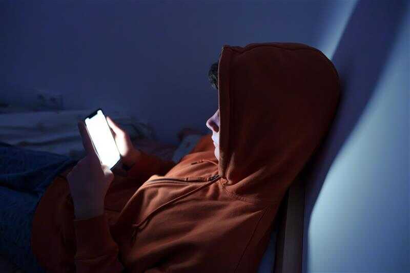 Adolescent sur son portable le soir